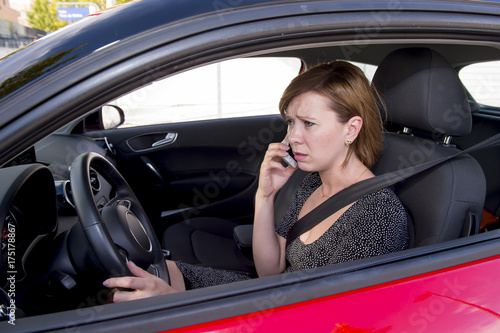 worried and stressed woman driving car while talking on the mobile phone distracted