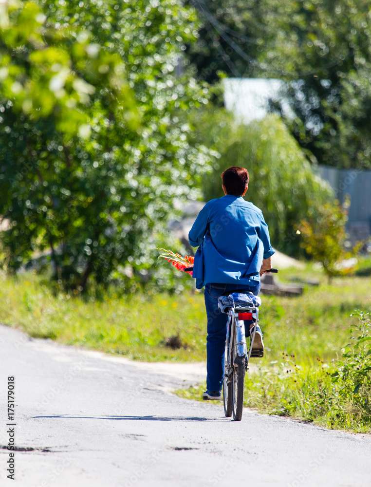 woman on a bicycle in the village