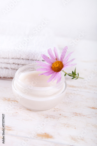 Moisturizing cream and blossoms on wooden background Close up.wellness setting
