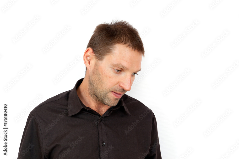 A young man looking down in disappointment A young man looking down in disappointment