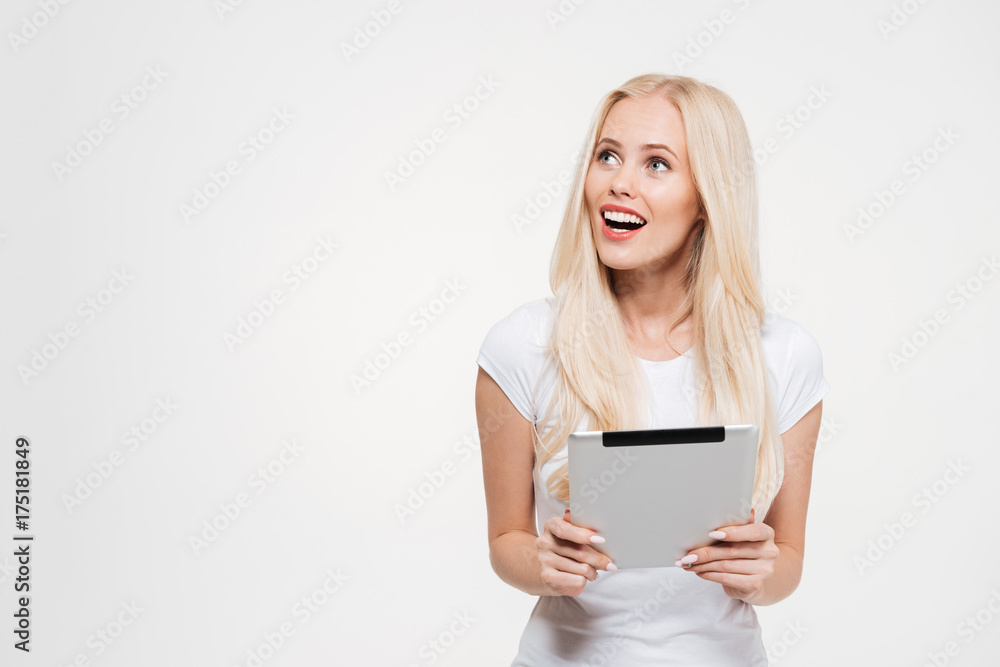 Fototapeta premium Portret podekscytowana blondynka gospodarstwa komputer typu tablet