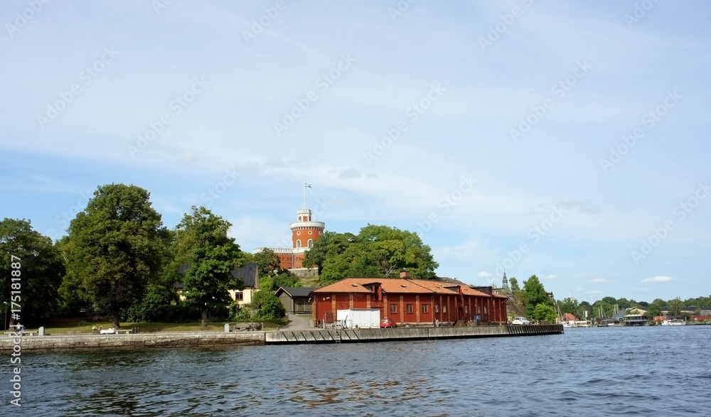 Scenic view of the small red castle, brick citadel Kastellet on the island Kastellholmen in central of the city, sunny day, Stockholm, Sweden Scenic view of the small red castle, brick citadel Kastellet on the island Kastellholmen in central of the city, sunny day, Stockholm, Sweden