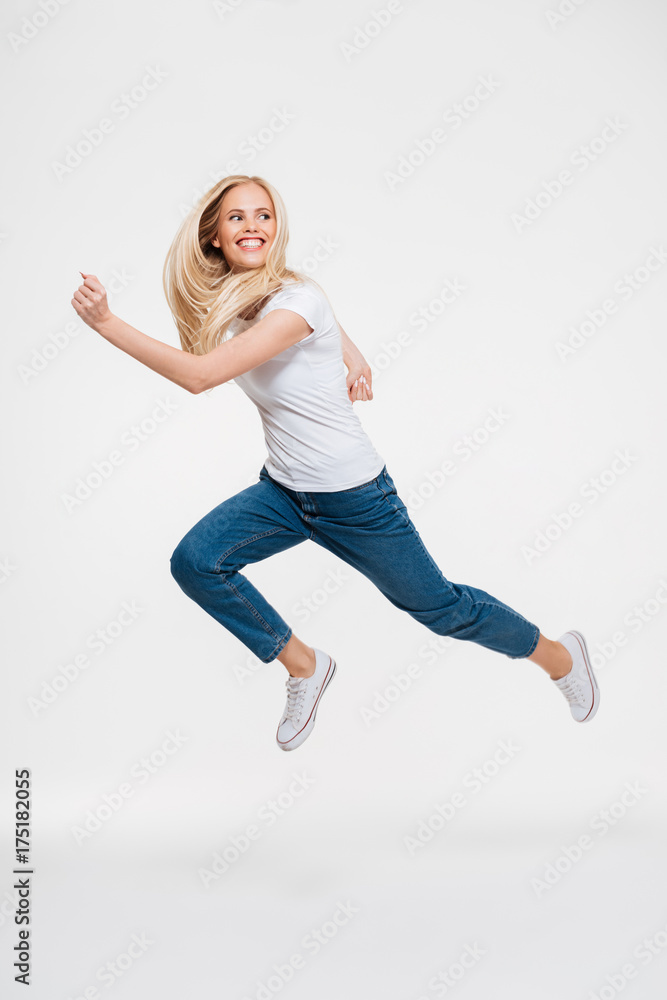 Full length portrait of a happy excited woman jumping