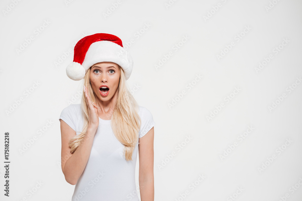 Portrait of a shocked pretty woman in red christmas hat Portrait of a shocked pretty woman in red christmas hat