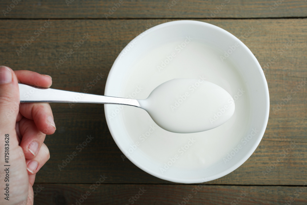 White yogurt in a spoon and a bowl White yogurt in a spoon and a bowl