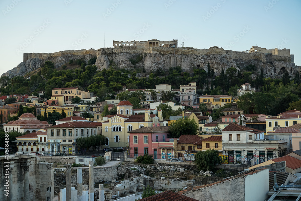 View of the Acropolis, Erechtheion, from Monasteraki Square through old town neighborhood buildings and Hadrian's Library ruins