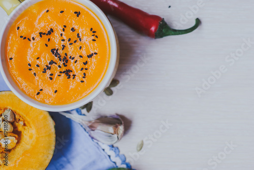 Homemade vegetable soup with pumpkin with cream and black sesame, top view with copy space photo