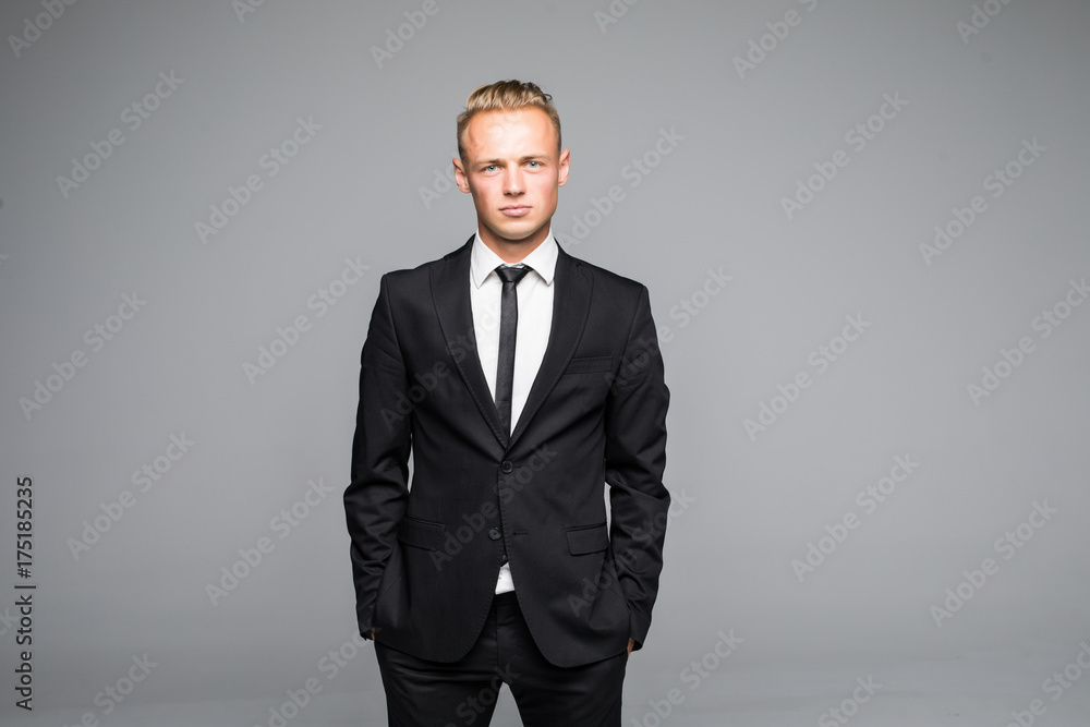 Picture of a young business man looking up while holding both hands in his pocket. Picture of a young business man looking up while holding both hands in his pocket.