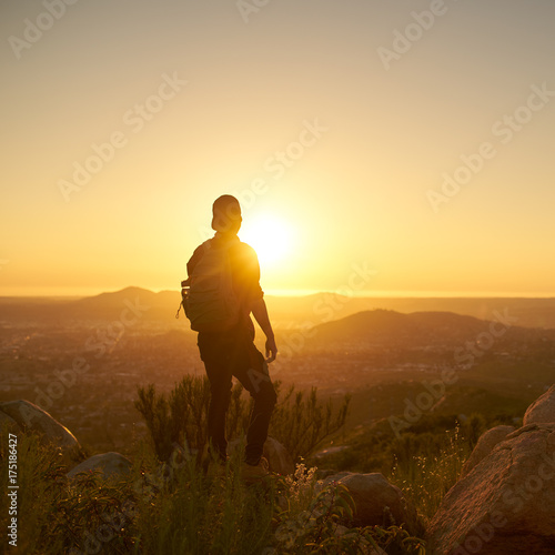 young bearded millennial man hiking on top of hill in california over looking san diego at sunset © Joshua Resnick