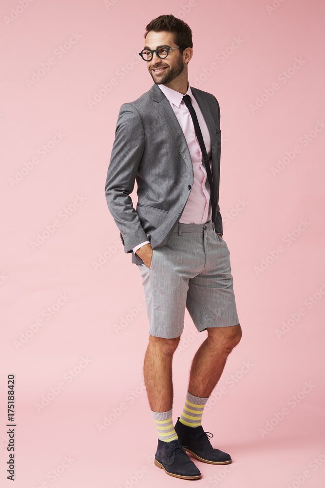 Happy guy in suit and shorts looking away in pink studio Happy guy in suit and shorts looking away in pink studio