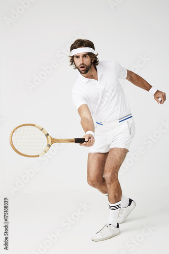 Serious tennis player aiming racket and ready to play
