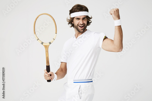 Cheering tennis dude with racket, portrait