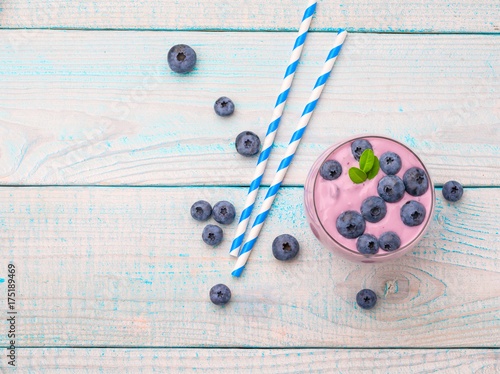 Blueberry smoothie in a glass on a rustic table.Top view