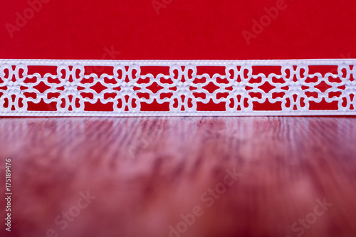 jul bakgrund vit metall spets likt band mot röd bakgrund med utrymme för egen text