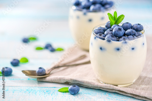 Berries of fresh blueberries  and yogurt on a wooden background