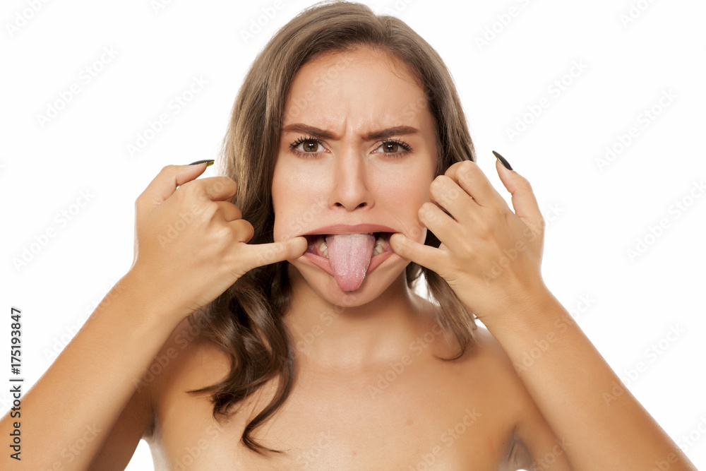 Fototapeta premium Portrait of beautiful young woman making funny faces on white background