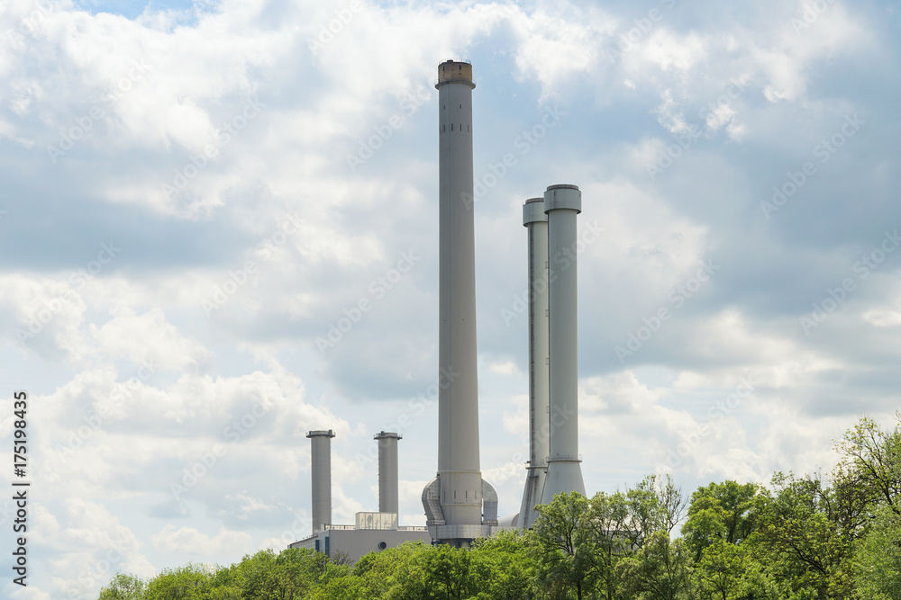High industrial chimneys over green trees in forest High industrial chimneys over green trees in forest