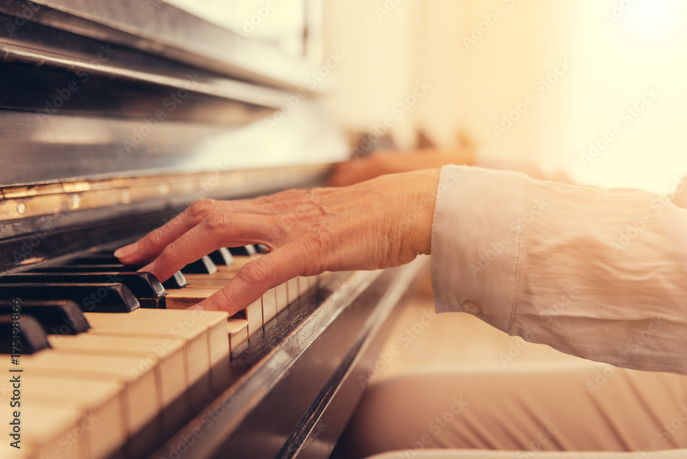 Fototapeta premium Close up of senior woman playing the piano