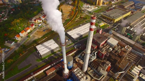 Camera flight over a modern combined heat and power plant. Fuming chimney with sulphur removal unit. Heavy industry from above. Power and fuel generation in European Union. 