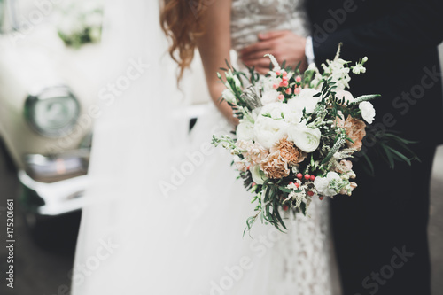 Beauty wedding bouquet with different flowers in hands