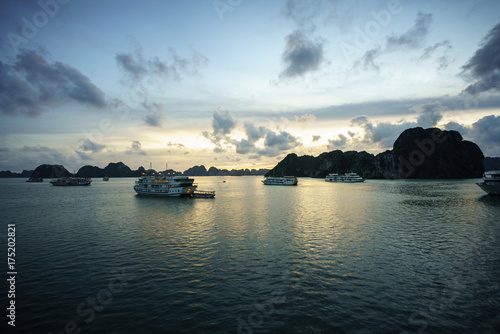 Halong bay at sunset with tourist cruise ships and rocky islands. Popular landmark  famous destination of Vietnam