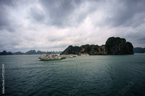 Halong bay at sunset with tourist cruise ships and rocky islands. Popular landmark, famous destination of Vietnam