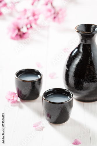 Unfiltered white sake sake with flowers of blooming cherry