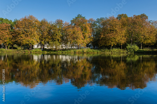 Autumnal landscape with colorful trees and their reflecion in water