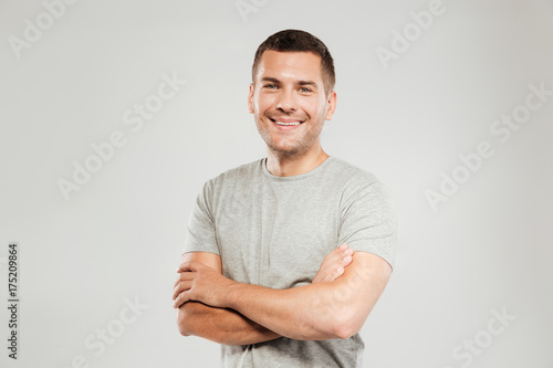 Happy young man with arms crossed. Looking at camera.