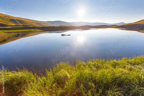 quiet mountain lake reflect a sun