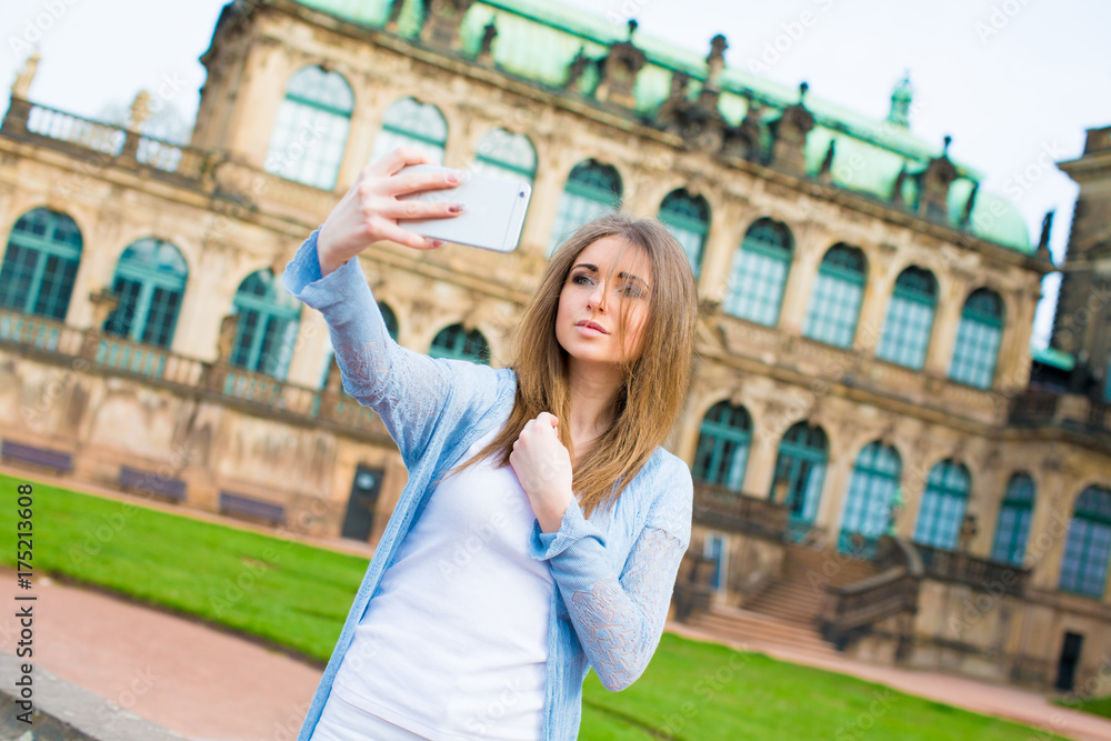 Girl makes photos shots of european city Dresden and selfie of background old German town