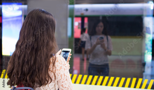 Girl using phone while waiting for subway