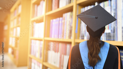 Graduates stand in the library of the College.
