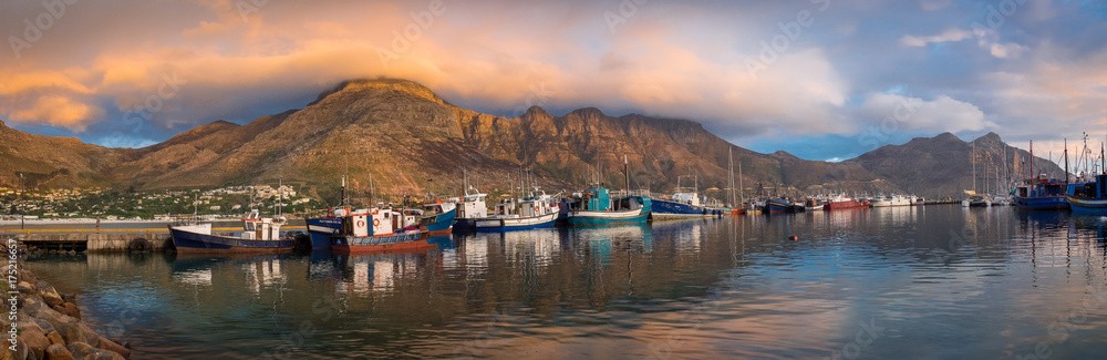 Obraz premium Hout Bay Harbor o zachodzie słońca, łodzie rybackie w złotym świetle