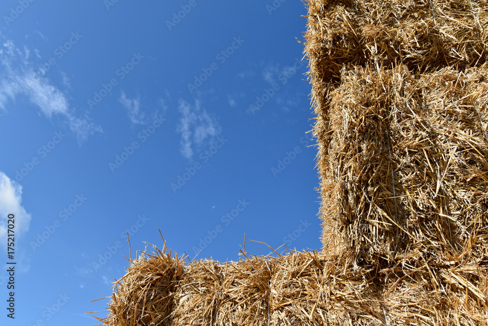 Stack of straw, square bundles straightened on each other. Blue sky. Stack of straw, square bundles straightened on each other. Blue sky.
