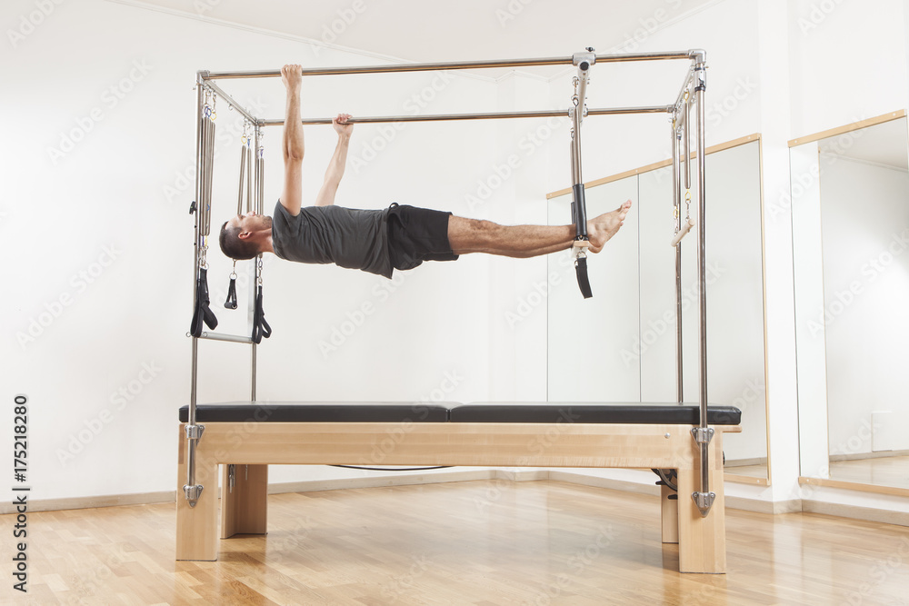 Obraz premium Pilates instructor performing exercise on cadillac equipment