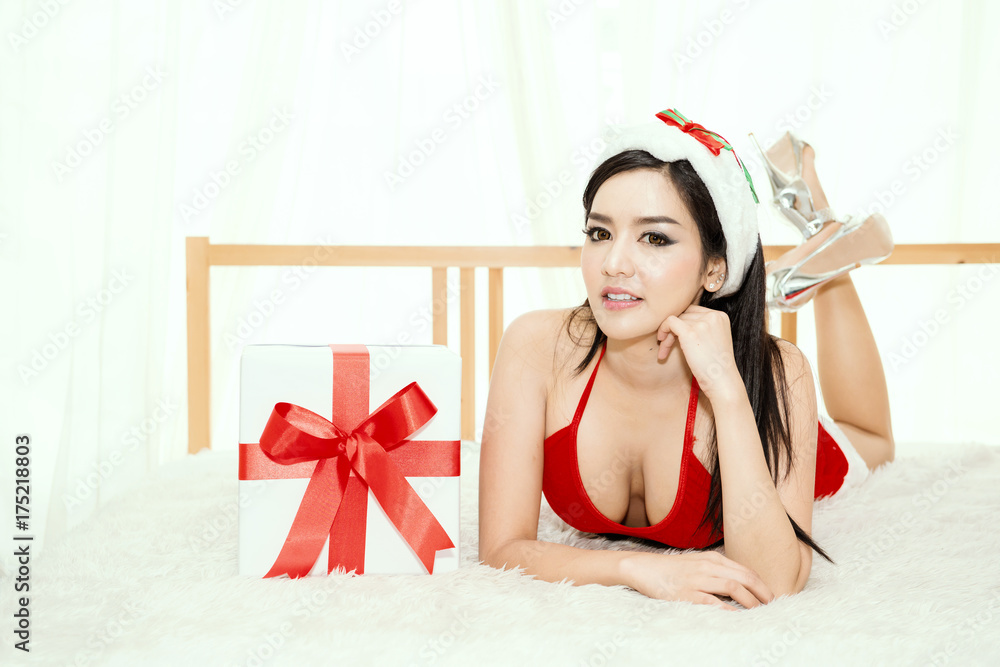sexy beautiful asian model young lady Pin Up girl posing on bed in hotel  wearing winter red Santa Claus hat costume with big gift box lovely cute  pose Stock Photo | Adobe