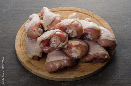 Fresh raw chicken legs arrangement on kitchen cutting board