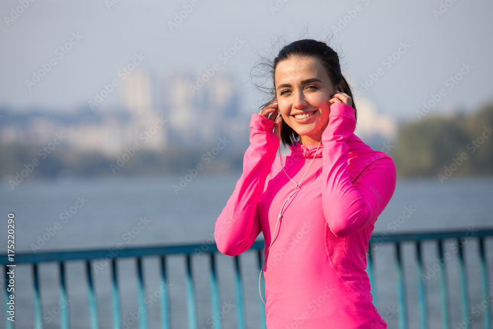 Smiling portrait of young woman in pink sportswear ready to jogging outdoors Smiling portrait of young woman in pink sportswear ready to jogging outdoors