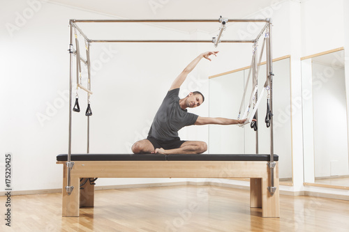 Obraz na plátně Pilates instructor performing exercise on cadillac equipment