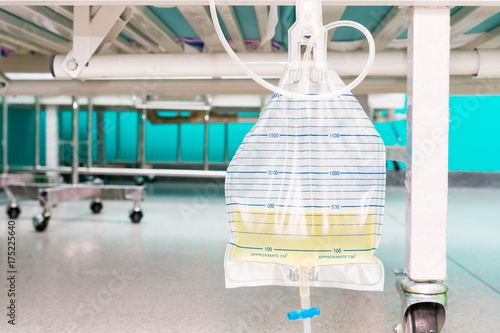 Urine bag hanging beside the patient's bed. Inside the hospital room. photo