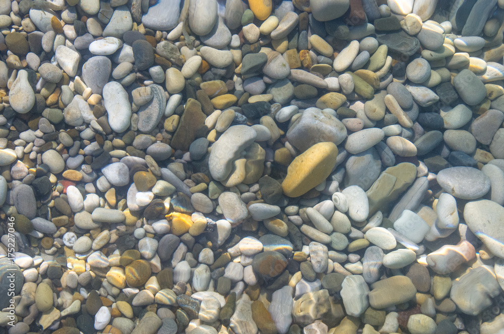 sea pebble beach with multicoloured stones, waves with foam sea pebble beach with multicoloured stones, waves with foam