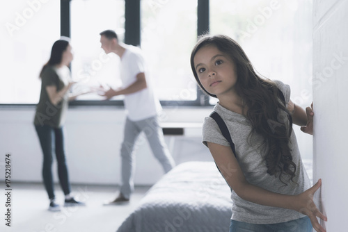 A man and a woman swear in the room. The dark-haired girl tries to escape imperceptibly from the apartment photo