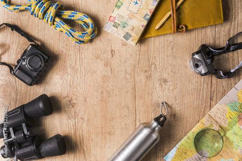 Overhead view of travel equipment for an adventure trip on wooden floor with copy space. Adventure travel concept.