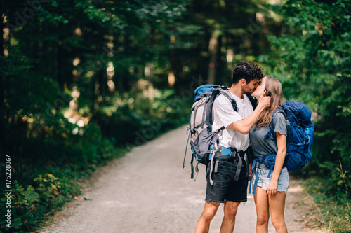 Hiking couple. Young couple with backpacks kissing