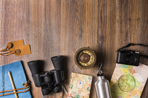 Overhead view of travel equipment for an adventure trip on wooden floor with copy space. Adventure travel concept.