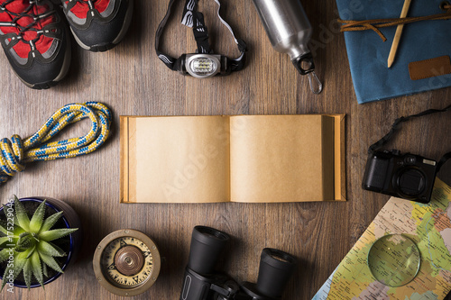 Overhead view of travel equipment for an adventure trip on wooden floor with copy space. Adventure travel concept.