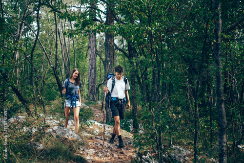Hiking couple. Young couple with backpacks walking through the forest   © Astarot