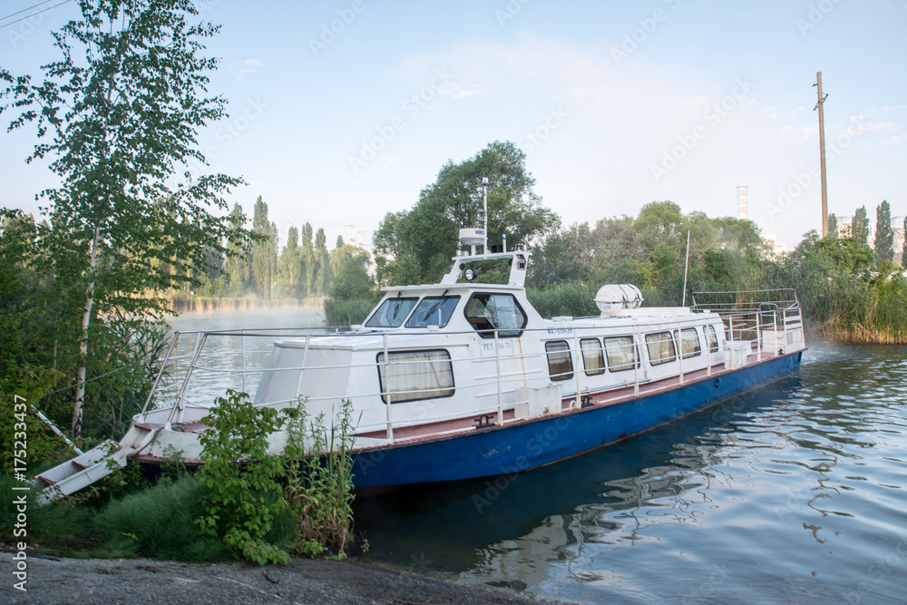 Naklejka premium white boat on the lake near the nuclear power plant