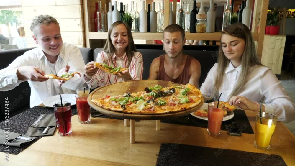 People taking pizza cuts from plate on table. People taking pizza cuts from plate on table.